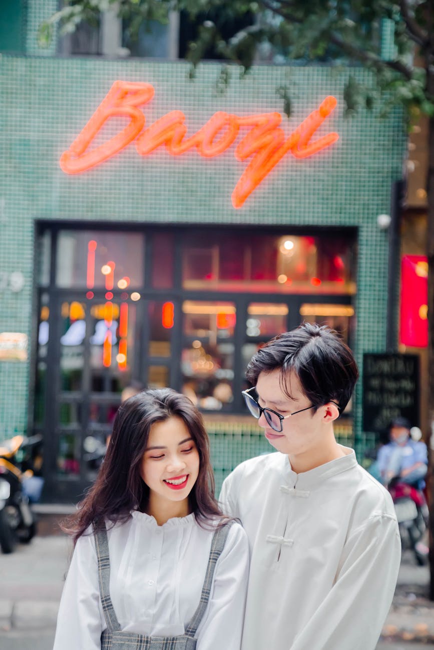 young couple standing on a street and restaurant in background